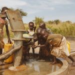 Group of children gathering water from a well in Kitgum, Uganda.