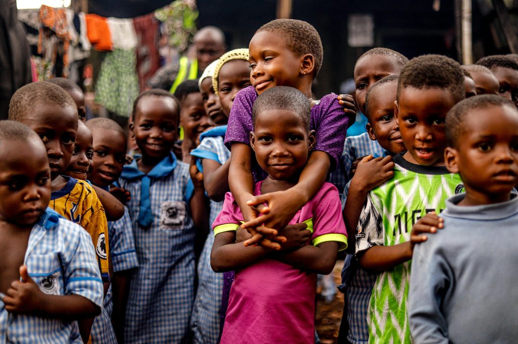 pexels photo 9968379 9968379 A heartwarming group of children smiling and embracing each other outdoors, showcasing joy and community.